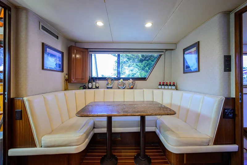 Slide: The Image of Interior of 1991 Hatteras 78 CMY yacht with cozy dining nook and window view. - 24