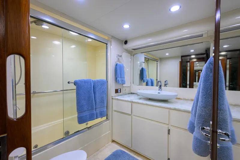 Slide: The Image of Luxurious bathroom on 1991 Hatteras 78 CMY yacht with modern fixtures and blue towels. - 35