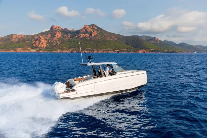 Slide: The Image of 2026 Beneteau Gran Turismo 35 cruising on blue ocean with scenic rocky coastline. - 2
