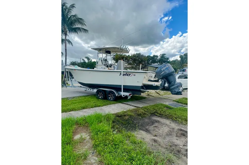 Slide: The Image of 2007 Parker 2501 Center Console boat on trailer, parked outdoors under cloudy sky. - 4