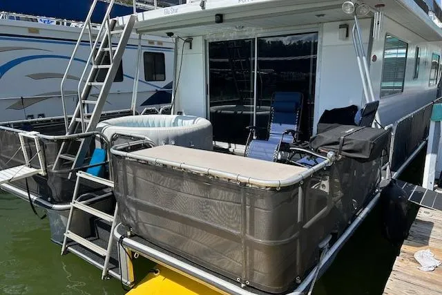Slide: The Image of 1987 Somerset Houseboat 14X60 docked, featuring white exterior and sliding windows. - 10