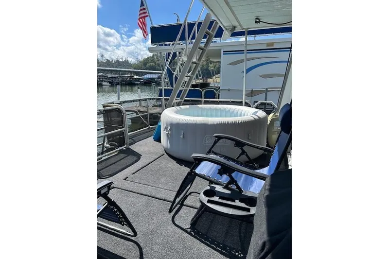 Slide: The Image of 1987 Somerset Houseboat 14X60 docked with black mesh enclosure. - 11