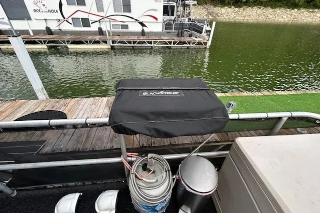 Slide: The Image of 1987 Somerset Houseboat 14X60 docked on a serene lake with lush greenery. - 12