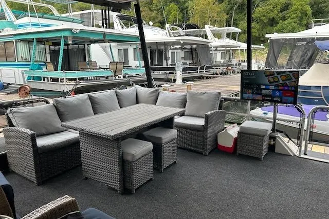 Slide: The Image of 1987 Somerset Houseboat 14X60 with deck, hot tub, and lounge chairs on the water. - 14