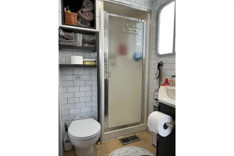 Slide: The Image of 1987 Somerset Houseboat 14X60 deck with wicker chairs and table, featuring a cozy outdoor setup. - 16