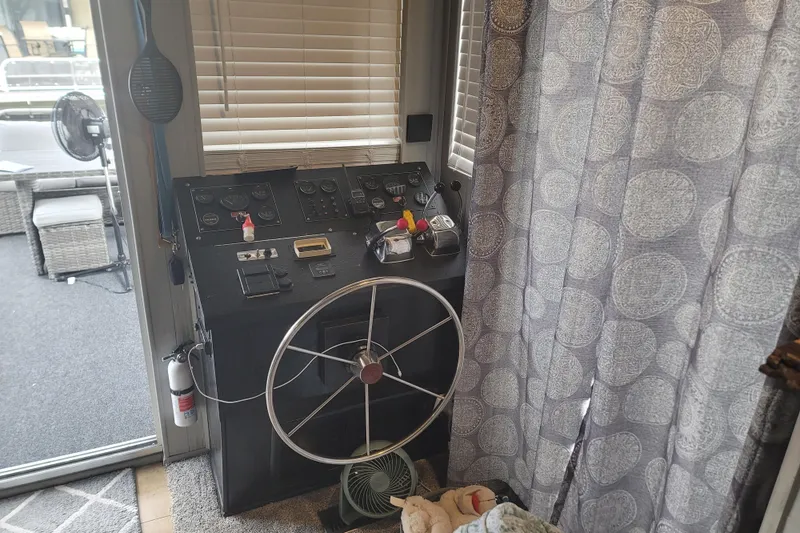 Slide: The Image of 1987 Sumerset 14x60 houseboat with outdoor seating, striped chairs, and scenic marina view. - 40