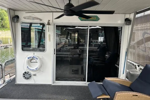 Slide: The Image of 1987 Somerset Houseboat 14X60 with black mesh enclosure on docked side. - 5