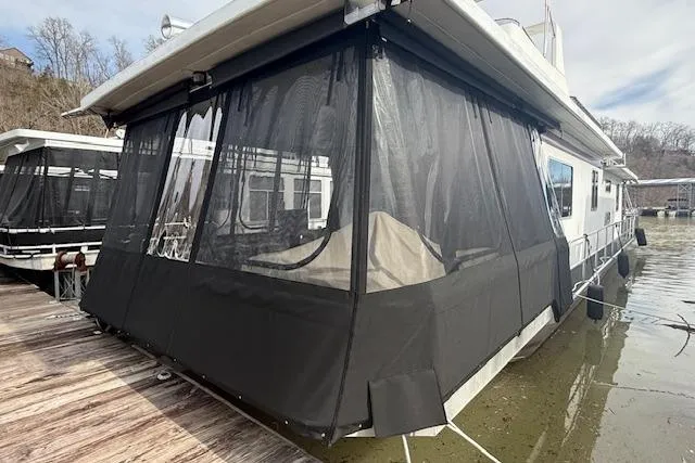 Slide: The Image of 1987 Somerset Houseboat 14X60 with black canvas enclosure on a calm water surface. - 7