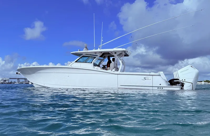 Slide: The Image of 2024 Scout 400 LXF boat on water under blue sky. - 18