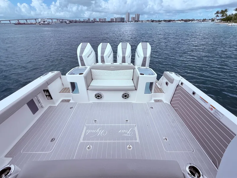Slide: The Image of 2024 Scout 400 LXF boat deck with four engines, overlooking a scenic waterfront. - 20