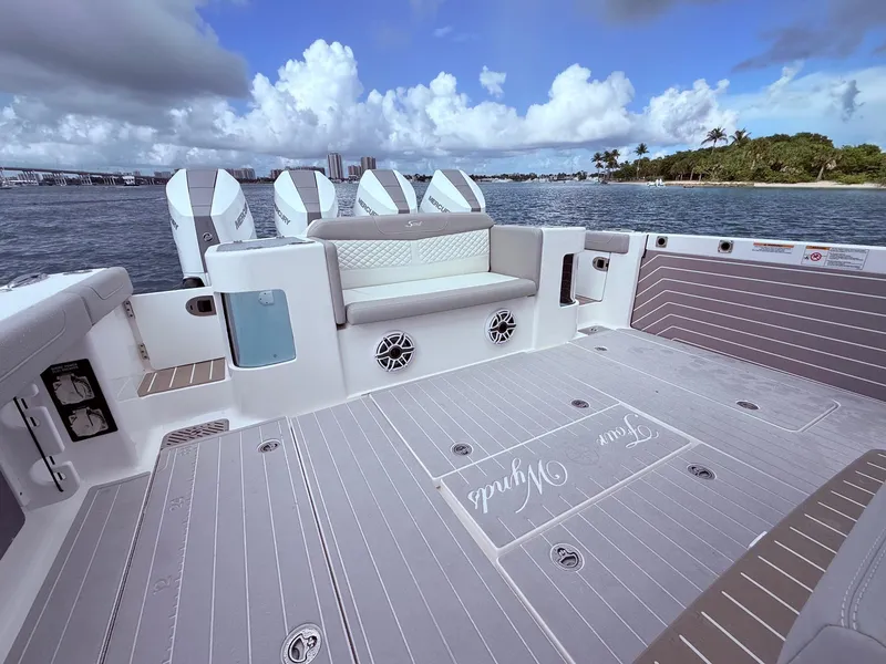 Slide: The Image of 2024 Scout 400 LXF boat deck with seating, ocean view, and four outboard engines. - 23