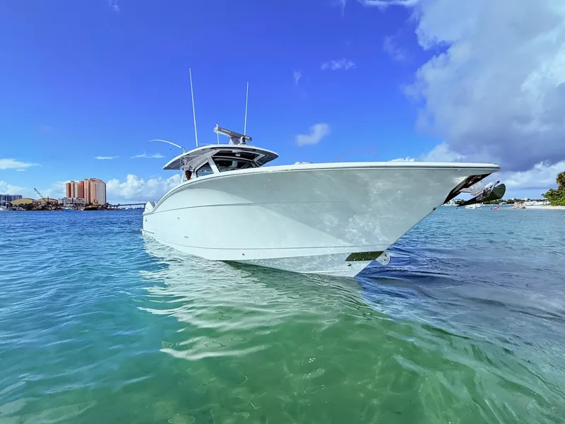 Slide: The Image of 2024 Scout 400 LXF boat on clear blue water under a bright sky. - 3