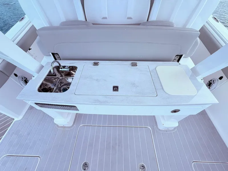 Slide: The Image of 2024 Scout 400 LXF boat interior with sink and cutting board on deck. - 33