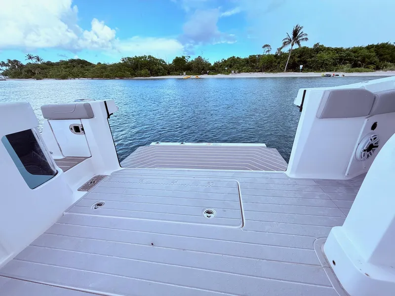 Slide: The Image of 2024 Scout 400 LXF boat deck overlooking serene water and lush shoreline. - 42