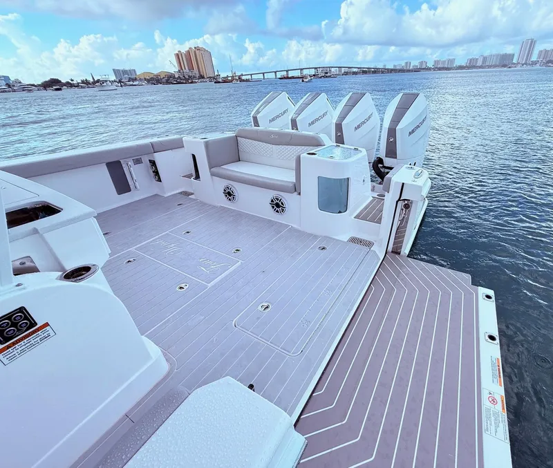 Slide: The Image of 2024 Scout 400 LXF boat deck with seating and Mercury engines, overlooking a scenic waterfront. - 43