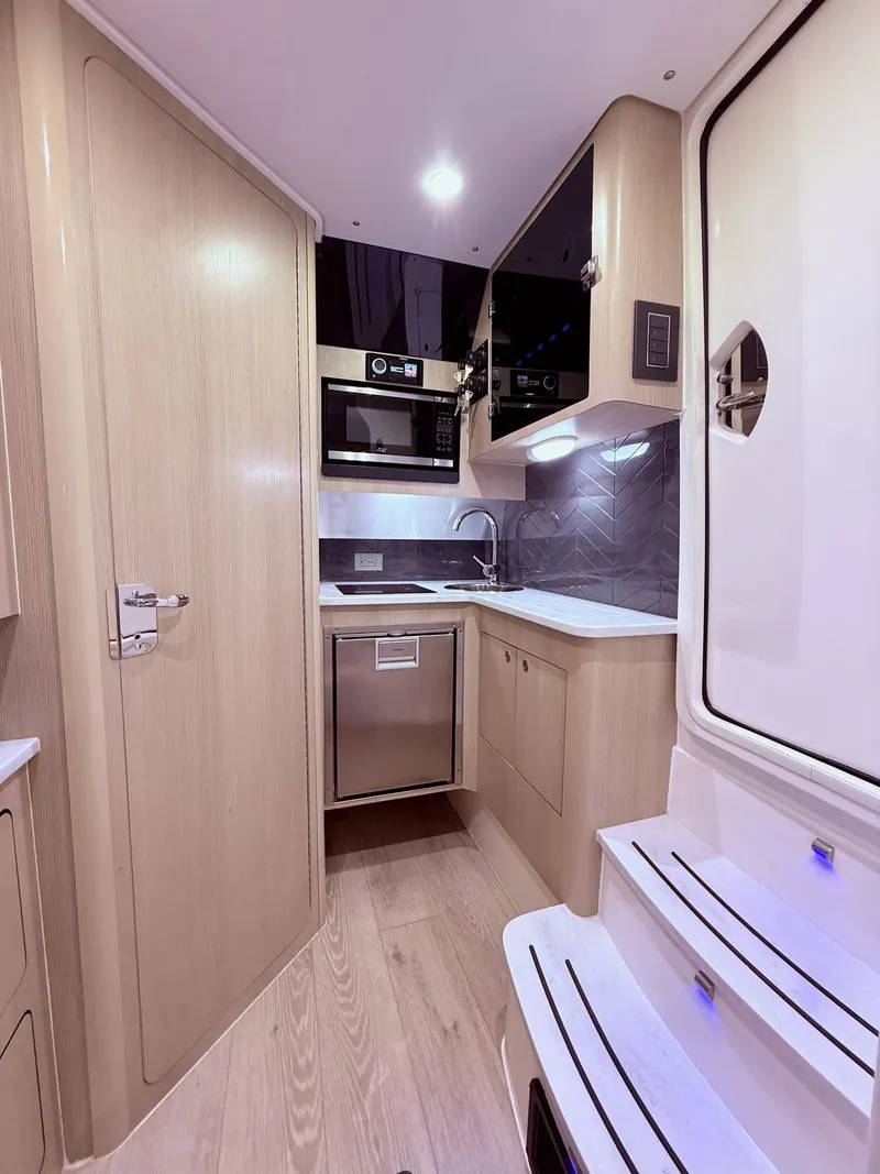 Slide: The Image of 2024 Scout 400 LXF interior kitchen with modern appliances and sleek design. - 50