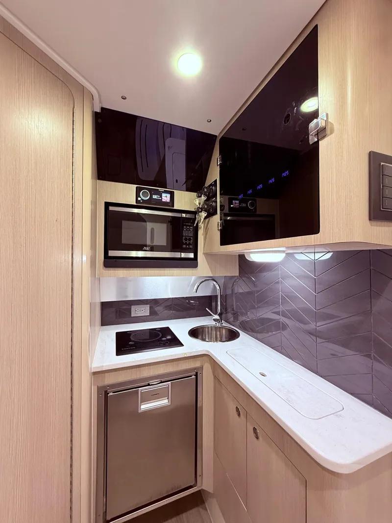 Slide: The Image of 2024 Scout 400 LXF yacht kitchen with modern appliances and sleek design. - 52