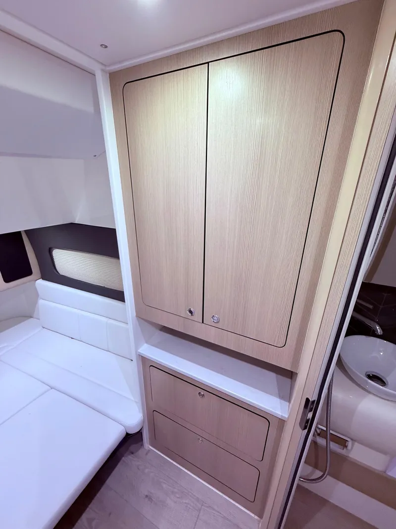 Slide: The Image of 2024 Scout 400 LXF cabin interior with wood cabinetry and seating area. - 55
