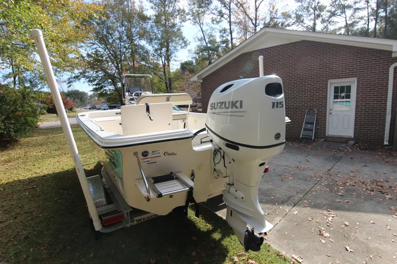Slide: The Image of 2022 Carolina Skiff 19 LS boat with Suzuki 115 outboard motor in a driveway. - 13