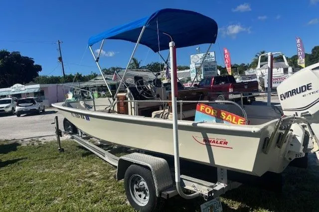 The Image of 1987 Boston Whaler 170 Montauk boat with blue canopy, for sale on a trailer. - 0