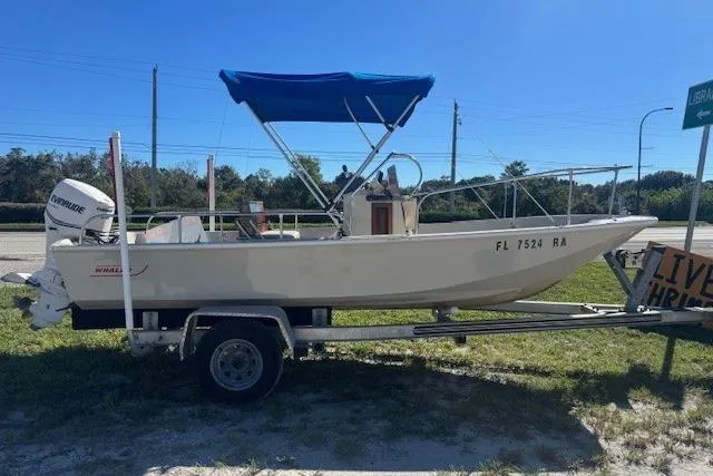 Slide: The Image of 1987 Boston Whaler 170 Montauk boat on trailer with blue canopy, parked outdoors. - 1