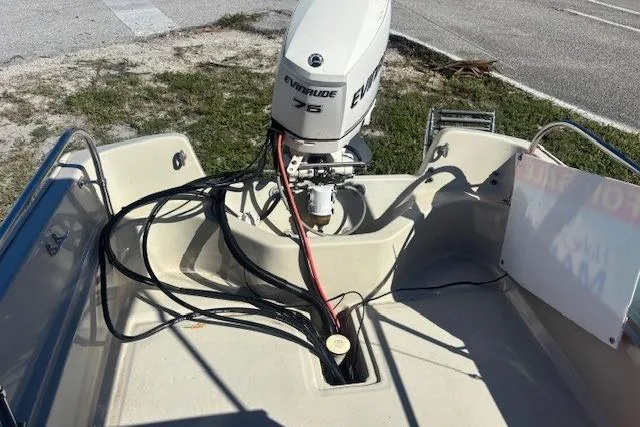 Slide: The Image of Boston Whaler 170 Montauk 1987 with Evinrude 75 outboard motor, parked on grass. - 8