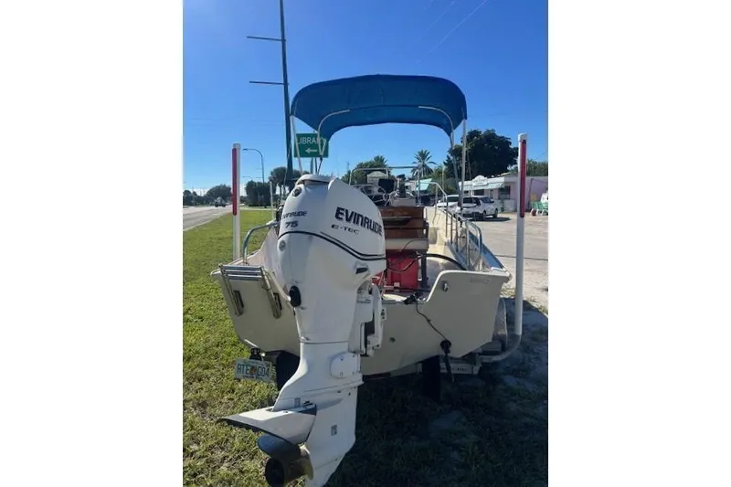 Slide: The Image of 1987 Boston Whaler 170 Montauk with Evinrude outboard motor, parked on grass. - 9