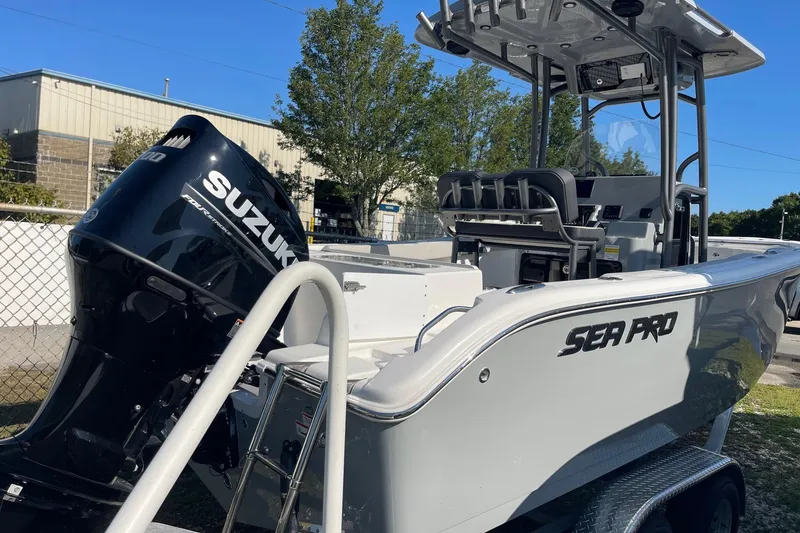 Slide: The Image of 2025 Sea Pro 222 Center Console boat with Suzuki outboard motor, parked outdoors. - 2
