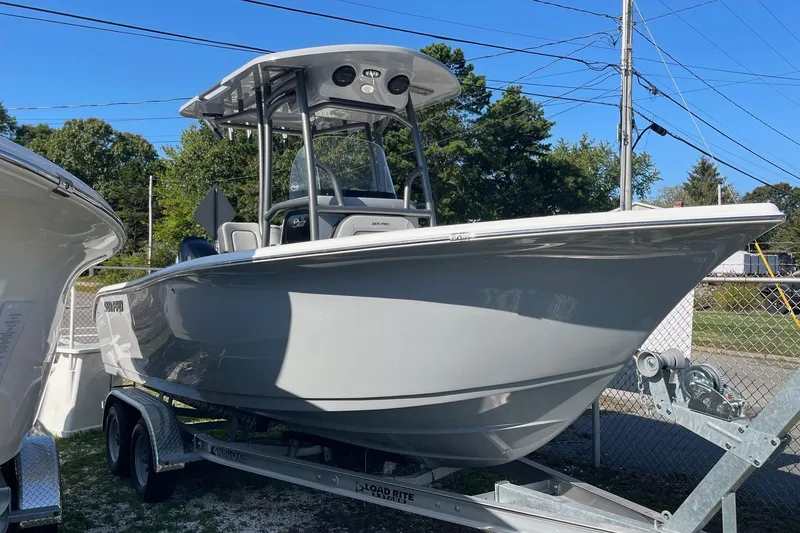 Slide: The Image of 2025 Sea Pro 222 Center Console boat on trailer, parked outdoors, under clear blue sky. - 3