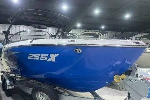 Slide: The Image of 2025 Yamaha Boats 255XD in showroom, blue hull, on trailer. - 0