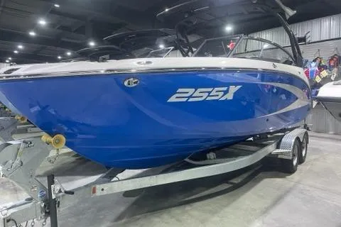 Slide: The Image of 2025 Yamaha Boats 255XD in showroom, blue hull, on trailer. - 1