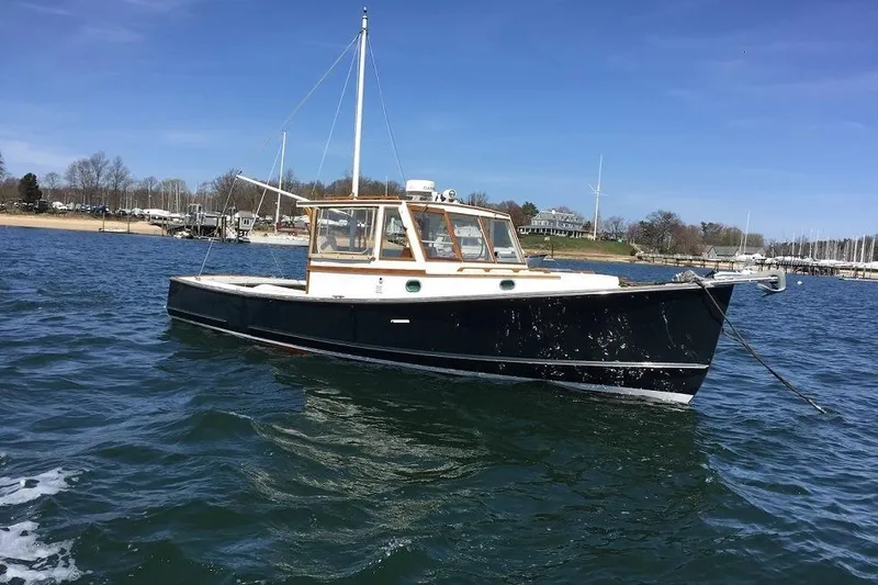 The Image of 1975 Jarvis Newman 32 DEC boat anchored on calm water near a shoreline. - 0