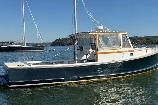 Slide: The Image of 1975 Jarvis Newman 32 DEC boat on calm water, clear sky background. - 1