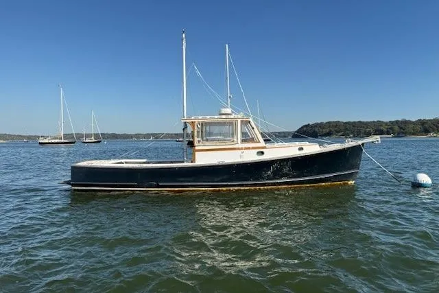 Slide: The Image of 1975 Jarvis Newman 32 DEC boat on calm water under clear blue sky. - 3