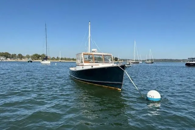 Slide: The Image of 1975 Jarvis Newman 32 DEC boat moored on calm water under clear blue sky. - 4