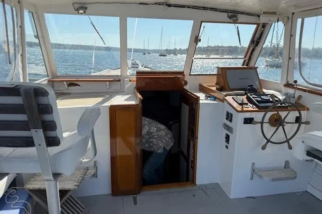 Slide: The Image of 1975 Jarvis Newman 32 DEC boat interior with steering wheel, open cabin door, and ocean view. - 40