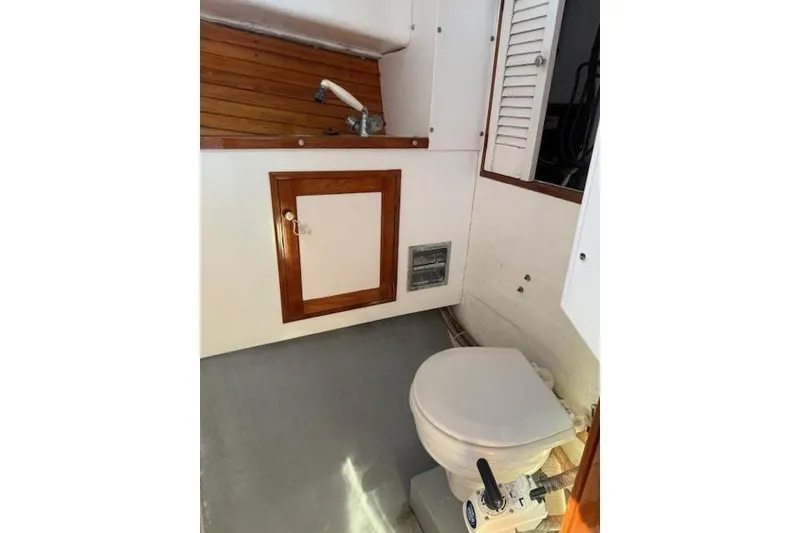 Slide: The Image of 1975 Jarvis Newman 32 DEC boat bathroom with toilet and wooden cabinetry. - 42