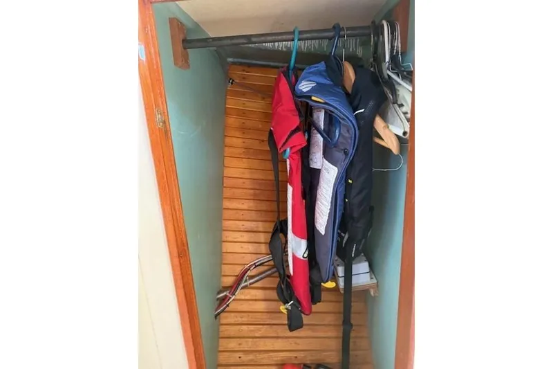 Slide: The Image of Hanging life jackets in a wooden closet on a 1975 Jarvis Newman 32 DEC boat. - 48