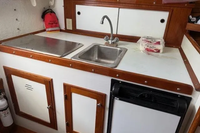 Slide: The Image of 1975 Jarvis Newman 32 DEC boat kitchen with sink, stove, and storage cabinets. - 54