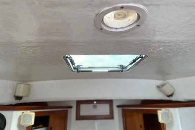 Slide: The Image of Interior view of a 1975 Jarvis Newman 32 DEC boat, featuring a ceiling hatch and lighting. - 56