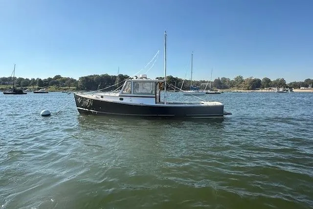 Slide: The Image of 1975 Jarvis Newman 32 DEC boat on calm water under clear blue sky. - 6