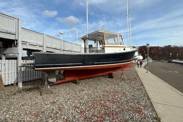 Slide: The Image of 1975 Jarvis Newman 32 DEC boat on dry dock, black hull, red bottom, clear sky. - 72