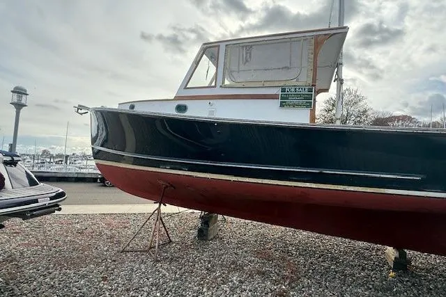 Slide: The Image of 1975 Jarvis Newman 32 DEC boat on display, black hull, for sale sign visible. - 75