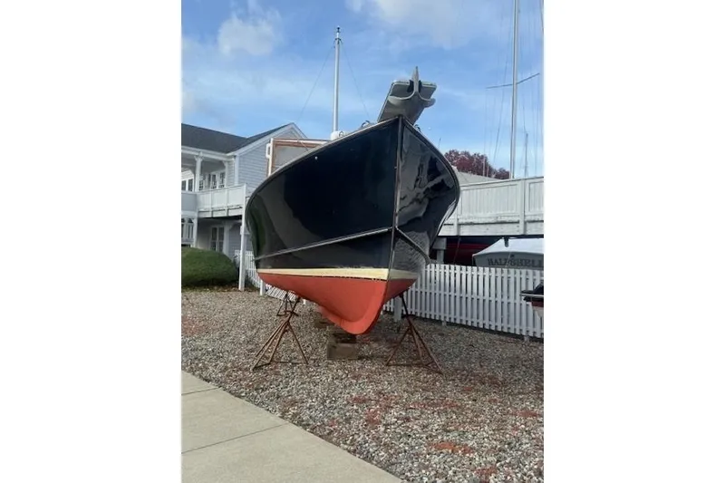 Slide: The Image of 1975 Jarvis Newman 32 DEC boat on stands, displayed outdoors near a white fence. - 77
