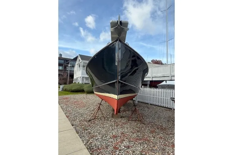 Slide: The Image of 1975 Jarvis Newman 32 DEC boat on land, displayed on gravel with a clear sky. - 78