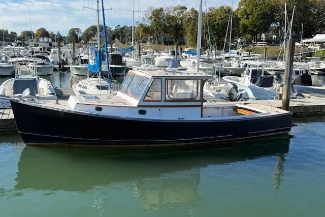 Slide: The Image of 1975 Jarvis Newman 32 DEC boat docked in a marina, surrounded by other vessels. - 8