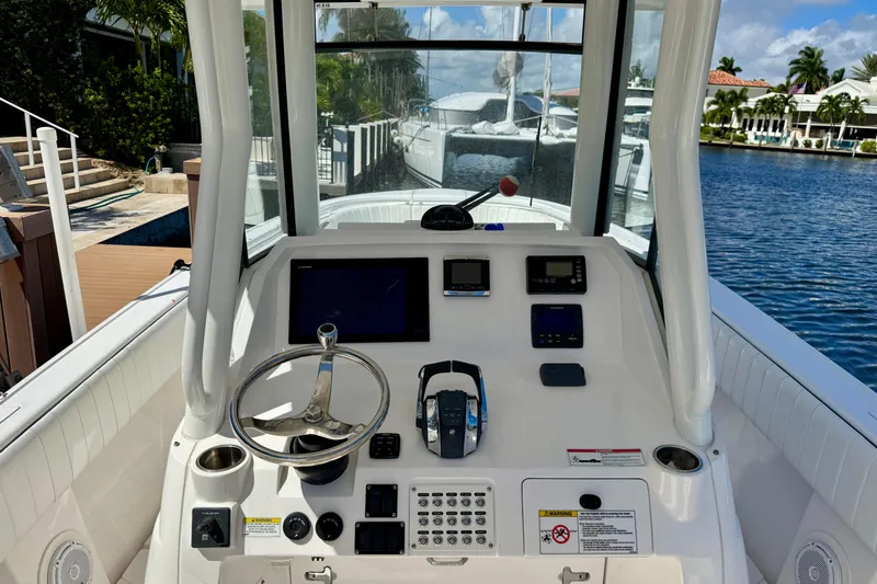 Slide: The Image of 2014 Intrepid 327 Center Console boat dashboard with steering wheel and navigation equipment. - 10