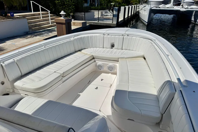Slide: The Image of 2014 Intrepid 327 Center Console boat with spacious white seating area at dock. - 13