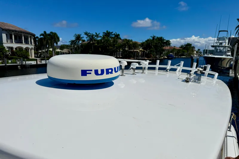 Slide: The Image of 2014 Intrepid 327 Center Console boat with Furuno radar, docked in a scenic waterfront area. - 15
