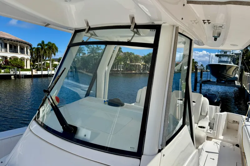 Slide: The Image of 2014 Intrepid 327 Center Console boat docked by waterfront homes. - 17